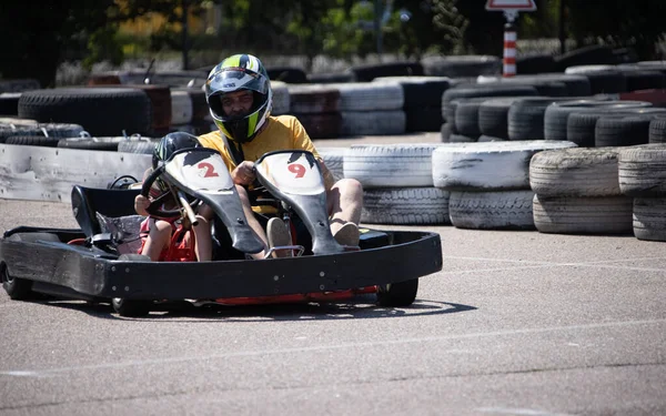 ODESSA, UKRAINE - August 7, 2022: Healthy lifestyle. Sport family. Family vacation at karting track. Children with parents go in for motorsports. Karting. Hobbies, sports education, leisure, lifestyle