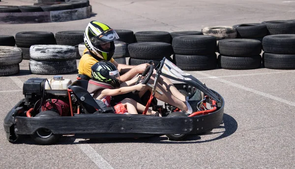 ODESSA, UKRAINE - August 7, 2022: Healthy lifestyle. Sport family. Family vacation at karting track. Children with parents go in for motorsports. Karting. Hobbies, sports education, leisure, lifestyle
