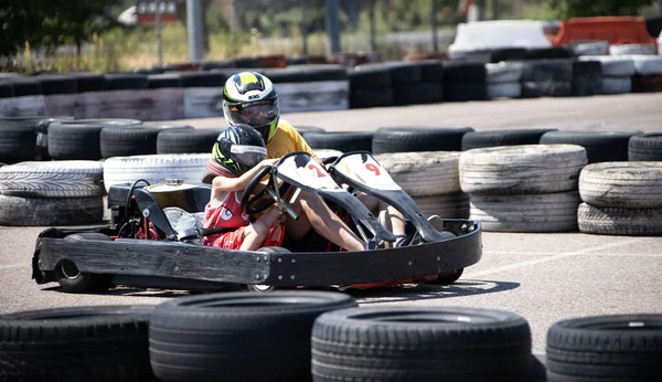 ODESSA, UKRAINE - August 7, 2022: Healthy lifestyle. Sport family. Family vacation at karting track. Children with parents go in for motorsports. Karting. Hobbies, sports education, leisure, lifestyle