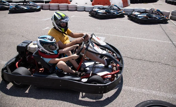 ODESSA, UKRAINE - August 7, 2022: Healthy lifestyle. Sport family. Family vacation at karting track. Children with parents go in for motorsports. Karting. Hobbies, sports education, leisure, lifestyle