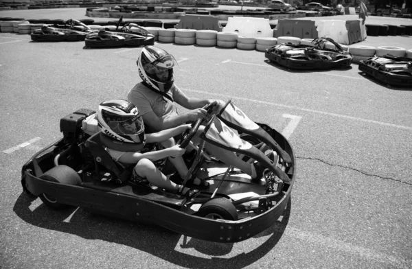 ODESSA, UKRAINE - August 7, 2022: Healthy lifestyle. Sport family. Family vacation at karting track. Children with parents go in for motorsports. Karting. Hobbies, sports education, leisure, lifestyle