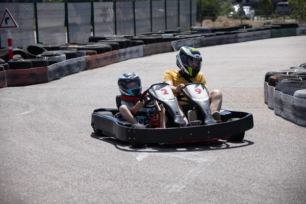 ODESSA, UKRAINE - August 7, 2022: Healthy lifestyle. Sport family. Family vacation at karting track. Children with parents go in for motorsports. Karting. Hobbies, sports education, leisure, lifestyle