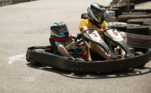 ODESSA, UKRAINE - August 7, 2022: Healthy lifestyle. Sport family. Family vacation at karting track. Children with parents go in for motorsports. Karting. Hobbies, sports education, leisure, lifestyle