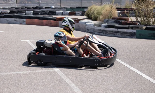ODESSA, UKRAINE - August 7, 2022: Healthy lifestyle. Sport family. Family vacation at karting track. Children with parents go in for motorsports. Karting. Hobbies, sports education, leisure, lifestyle