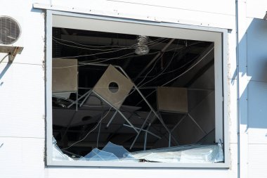 Broken Shopping center after shelling by Russian military. Result of missile explosion during war against Ukraine. Broken facade of building, destroyed ventilation, life support systems from explosion