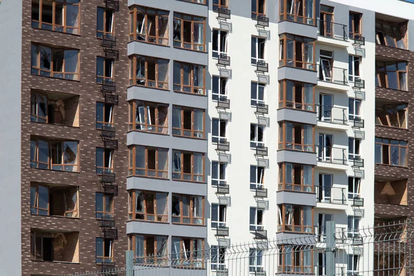 Broken windows of residential civilian building after Russian rocket exploded during Russian war against Ukraine. Broken glass windows, broken window frames from explosion. Russian invasion concept