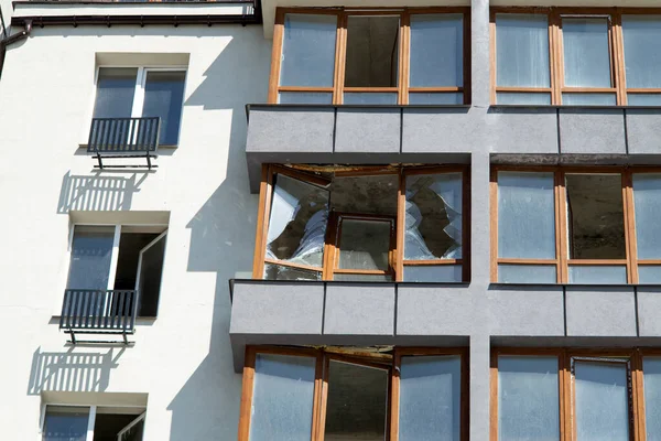 Broken windows of residential civilian building after Russian rocket exploded during Russian war against Ukraine. Broken glass windows, broken window frames from explosion. Russian invasion concept