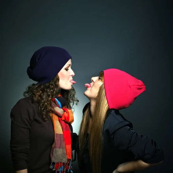 Portrait of two female friends in playful mood against grey background — Stock Photo, Image