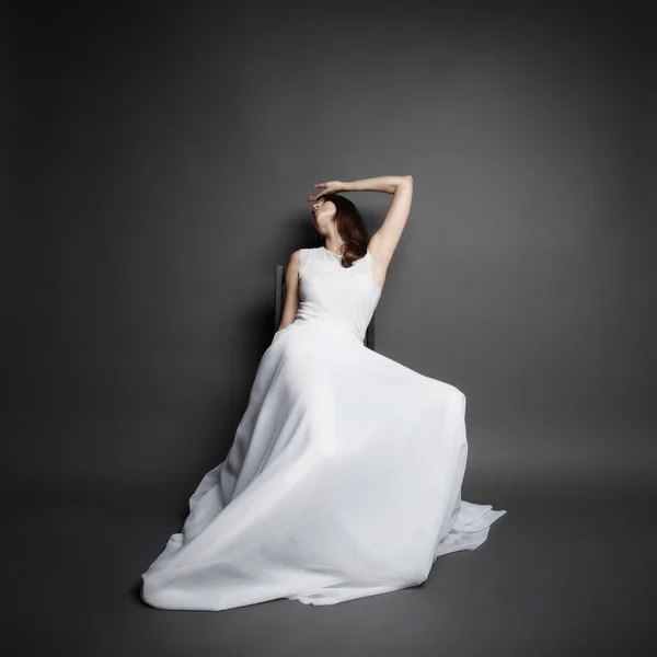 Krásná bruneta žena nosí v elegantní bílé šaty — Stock fotografie