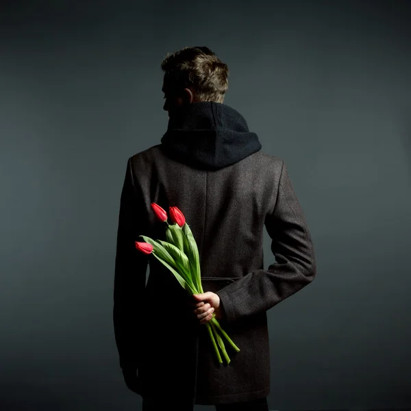 Young beautiful man with flowers — Stock Photo, Image