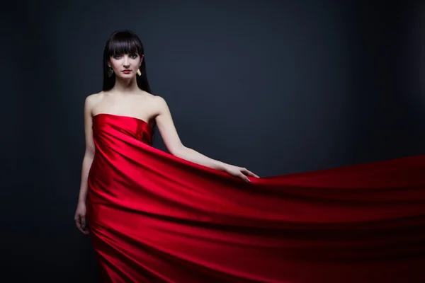 Belle fille en robe rouge sur fond noir — Photo
