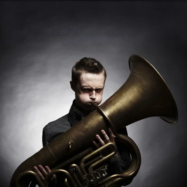 Portrait d'un jeune homme jouant sur le tuba doré — Photo