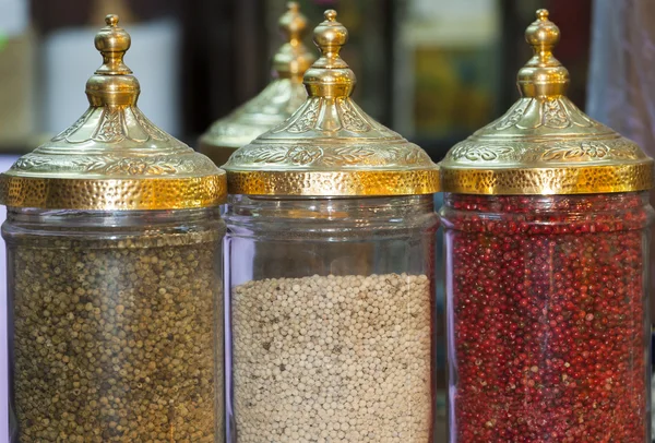 Peppercorns in ornate jars — Stock Photo, Image