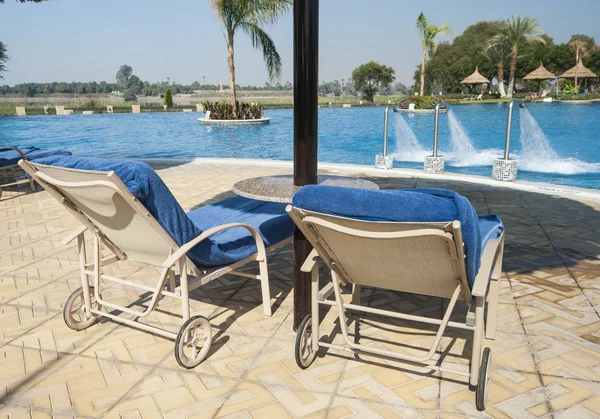 Sunbeds next to tropical pool — Stock Photo, Image