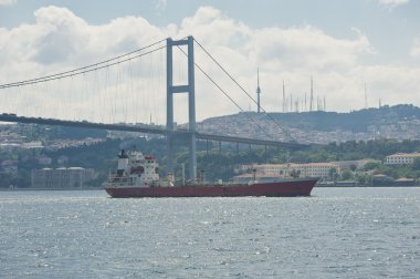 nehir üzerinde bir asma köprü altında büyük bir gemi