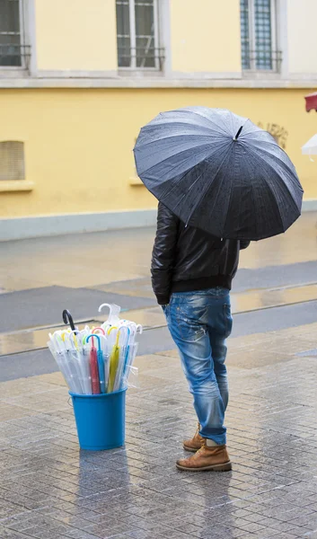 Man selling umbrellas stood in street — Stock Photo, Image