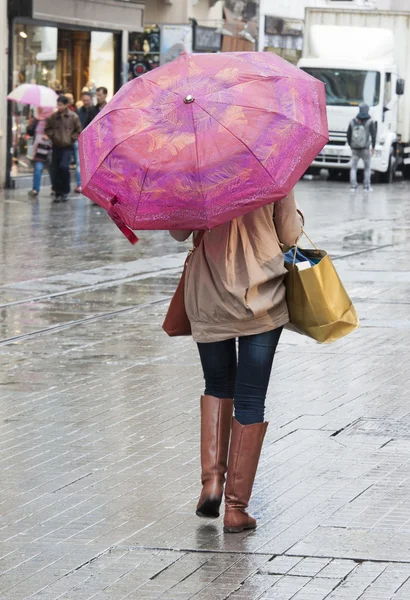 Mujer con paraguas caminando por la calle — Foto de Stock