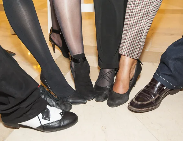 Collectie van schoeisel op volkeren voeten — Stockfoto