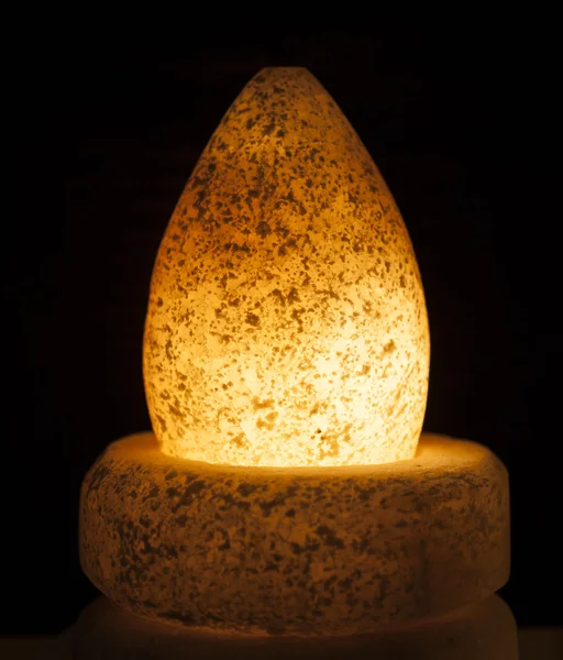 Ornate rock salt lamp on black background — Stock Photo, Image
