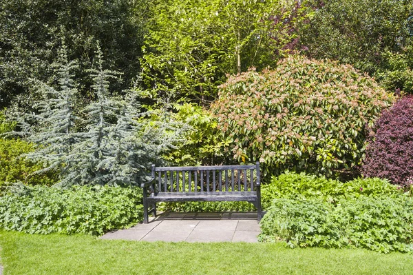 公园的长椅上，在美丽的花园中设置 — 图库照片
