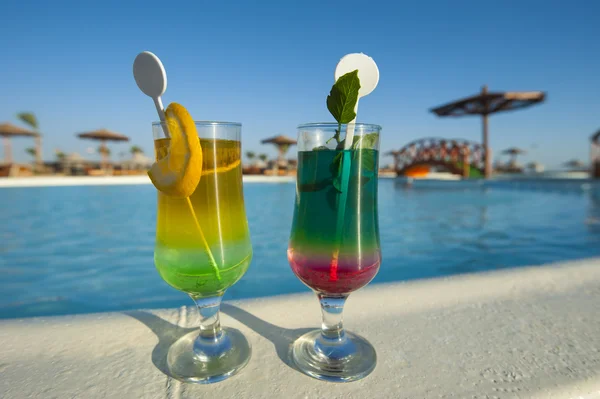 To cocktaildrinks ved en tropisk pool - Stock-foto