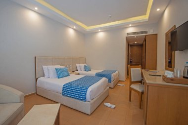 Lüks bir otel odasının içinde iç dekorasyon mobilyaları olan ikiz yataklar.