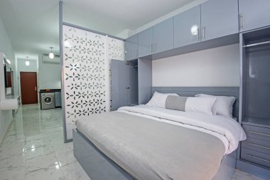 Lüks mobilyaların iç tasarım dekorasyonu. Stüdyo daire yatak odası. Mobilyalar ve çift kişilik yatak.