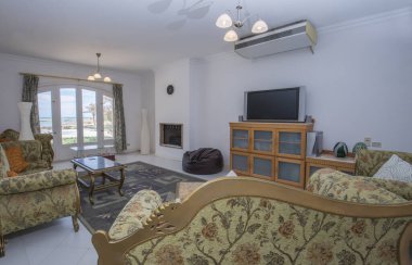Lüks tatil köşkündeki oturma odası iç dekorasyon dekorasyonu ve tropikal deniz manzarasını gösteren evi gösteriyor.