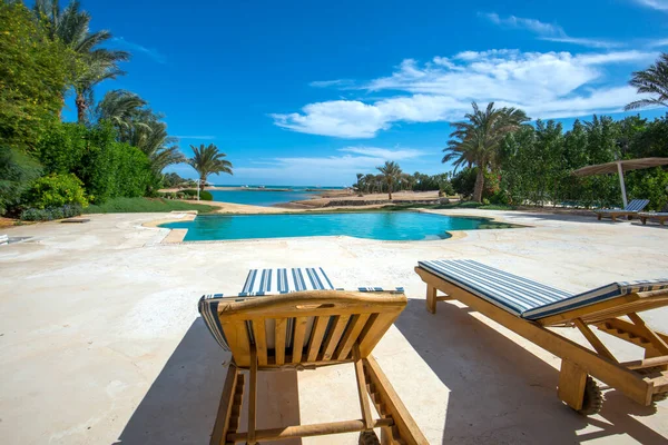 海の景色のスイミングプールとサンチェア付きの熱帯夏の休日のリゾートで豪華なヴィラショーの家 — ストック写真