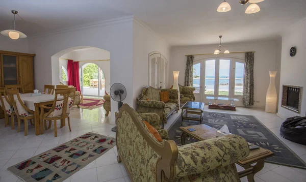 豪華な休日のヴィラショーの家のオープンプランリビングラウンジインテリアデザインの家具や熱帯の海の景色を示す — ストック写真