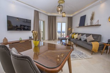 Lüks apartmandaki oturma odasının oturma odası balkon terası ve yemek masasıyla döşenmiş iç dekorasyon dekorasyonunu gösteriyor.