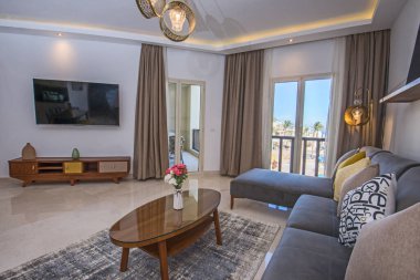 Lüks apartmandaki oturma odası salonu balkon terası döşenmiş iç dizayn dekorasyonunu gösteriyor.
