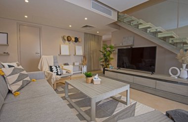 Lüks tropikal tatil dubleks apartmanındaki oturma odası oturma odası iç tasarım dekorasyonunu açık tasarım döşenmiş olarak gösteren evi gösteriyor.