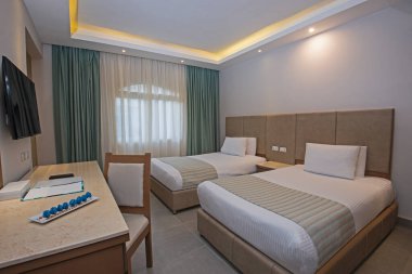 Modern iç dekorasyon mobilyaları olan lüks bir otel odasındaki ikiz yataklar.