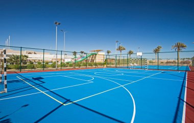 Açık havada, mavi yüzeyi ve tropik otel tatil beldesinde ağları olan çok amaçlı spor sahası.