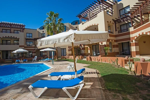 一个豪华热带酒店度假地的游泳池 内有建筑物和日光浴室 — 图库照片