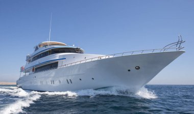 Lüks özel motor yatı tropikal denizde dalgalı bir şekilde yol alıyor.