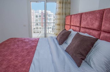 Lüks mobilyaların iç dizayn dekorasyonu ev yatak odasını gösteriyor ve çift kişilik yatak ve balkon.