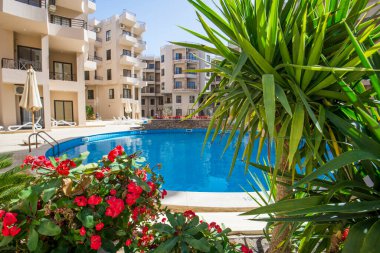 Lüks bir tropikal otel tesisinde bitkilerle dolu büyük bir yüzme havuzu.