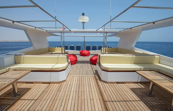 椅子ソファテーブルと熱帯の海の景色を背景に大きな高級モーターヨットの木製のサンデッキをチーク材 — ストック写真