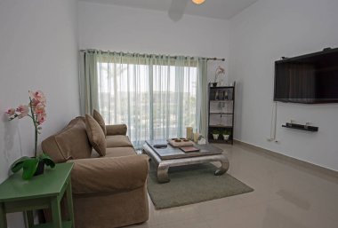 Lüks tropikal tatil dubleks apartmanındaki oturma odası oturma odası iç tasarım dekorasyonunu açık tasarım döşenmiş olarak gösteren evi gösteriyor.