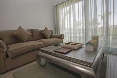 Lüks tropikal tatil dubleks apartmanındaki oturma odası oturma odası iç tasarım dekorasyonunu açık tasarım döşenmiş olarak gösteren evi gösteriyor.