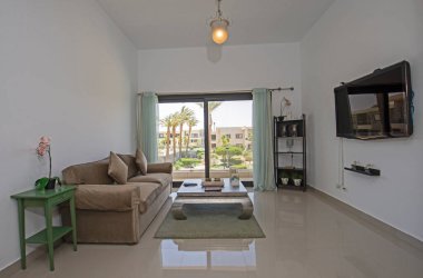 Lüks tropikal tatil dubleks apartmanındaki oturma odası oturma odası iç tasarım dekorasyonunu açık tasarım döşenmiş olarak gösteren evi gösteriyor.