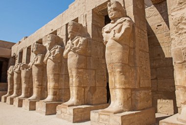 Antik Mısır Karnak Tapınağı 'nda avlu bölgesinde sütunları olan Ramses III' ün büyük heykelleri.