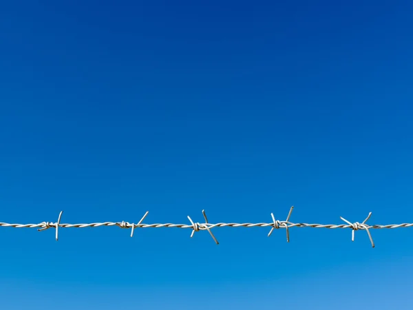 Alambre de afeitar blanco cielo azul — Foto de Stock