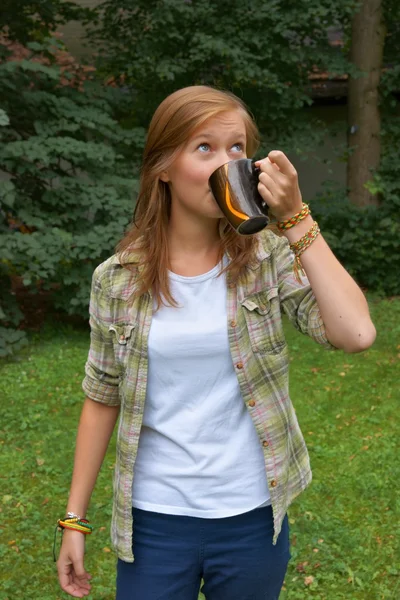 Teenager, ragazza che beve una tazza di caffè in giardino — Foto Stock