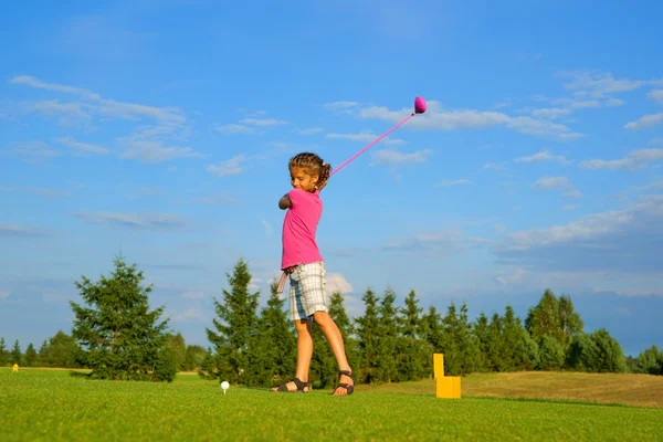 Гольф, девочка-гольфист собирается ударить по мячу — стоковое фото