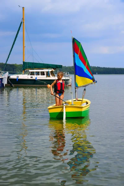 Vela, Chica fluye en un velero en el lago, en el puerto deportivo de fondo para yates — Foto de Stock
