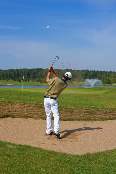 Golf, golfeur frappant la balle du bunker — Photo