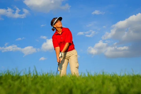 Golf, woman golfer observing the flight of the ball — Stock Photo, Image